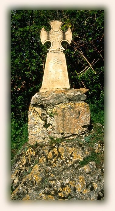 A stone monument with a cross on top of it.