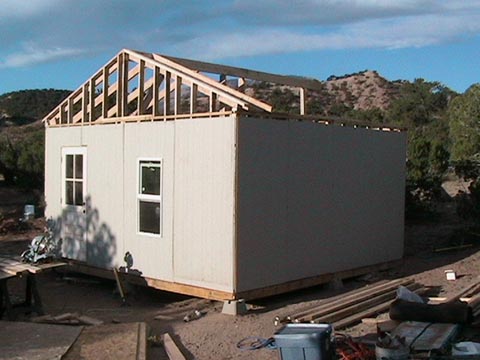 A building being built with some wood on the side.