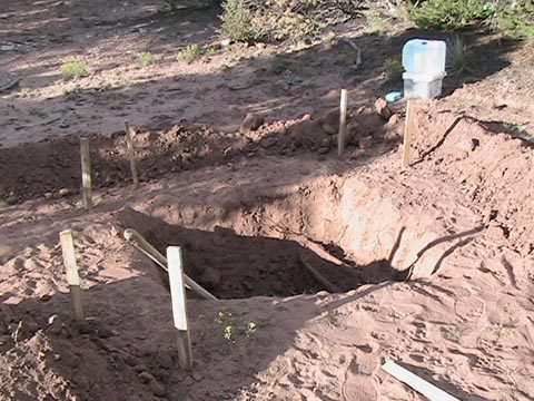 A hole in the ground with water leaking out.