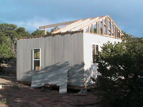 A house with some windows and a roof that is being built.