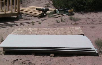 A construction site with a metal sheet laying on the ground.