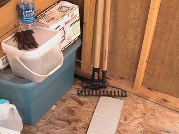 A room with a bucket and some tools on the floor