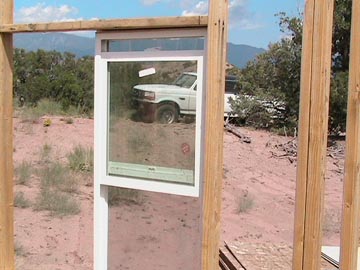 A truck is parked in the desert behind a window.